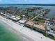 Expansive aerial shot of coastal residences, boasting pristine beachfront access and waterfront living at 202 Howard Dr, Belleair Beach, FL 33786
