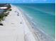 Breathtaking view of the coastline with pristine sandy beaches, calm waves, and swaying palm trees at 202 Howard Dr, Belleair Beach, FL 33786