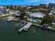 Waterfront home with a private dock, boat lift, and inviting swimming pool, surrounded by lush landscaping at 202 Howard Dr, Belleair Beach, FL 33786