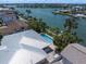 Aerial view displaying the pool, outdoor kitchen, and metal roof of a waterfront property at 202 Howard Dr, Belleair Beach, FL 33786