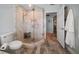 Bathroom featuring walk-in shower with glass door, and wood-look tile floors at 202 Howard Dr, Belleair Beach, FL 33786