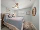 Comfortable bedroom featuring a ceiling fan, wood floors, plantation shutters and calm decor at 202 Howard Dr, Belleair Beach, FL 33786