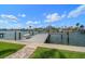 Backyard dock with boat lift on the canal under a sunny sky at 202 Howard Dr, Belleair Beach, FL 33786