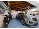 Spacious garage with epoxy floors, a car, bikes and scooters for easy parking and recreation at 202 Howard Dr, Belleair Beach, FL 33786