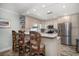 Well-lit kitchen featuring custom cabinets, stainless steel appliances, and a breakfast bar with unique seating at 202 Howard Dr, Belleair Beach, FL 33786
