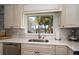 Bright kitchen view showcasing countertop space, neutral cabinets, and a scenic backyard view at 202 Howard Dr, Belleair Beach, FL 33786