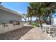 Outdoor kitchen on a brick patio overlooking a lush green yard, the canal, and palm trees at 202 Howard Dr, Belleair Beach, FL 33786
