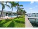 Waterfront home featuring a pool, manicured lawn, and private dock access at 202 Howard Dr, Belleair Beach, FL 33786