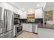 Modern kitchen featuring stainless steel appliances, white cabinetry, and a stylish dark backsplash at 204 Mindy Dr, Largo, FL 33771