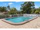 Community swimming pool with surrounding lounge chairs and a secure fence at 204 Mindy Dr, Largo, FL 33771