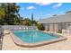Community swimming pool with surrounding lounge chairs and a secure fence at 204 Mindy Dr, Largo, FL 33771