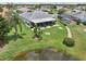 Aerial view of the home featuring screened lanai, landscaping, and view of the pond at 2306 Emerald Lake Dr, Sun City Center, FL 33573