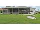 A spacious lawn and well-kept yard showcasing a screened-in patio for outdoor living at 2306 Emerald Lake Dr, Sun City Center, FL 33573