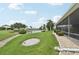 Lakefront backyard view featuring lush landscaping, a tranquil lake, and a screened lanai at 2306 Emerald Lake Dr, Sun City Center, FL 33573