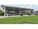 Exterior view of screened in patio, landscaped yard, and well-maintained greenery at 2306 Emerald Lake Dr, Sun City Center, FL 33573