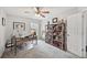Bright bedroom featuring a ceiling fan, gray carpet, built in shelves, and a workspace at 2306 Emerald Lake Dr, Sun City Center, FL 33573