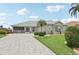 Inviting home with lush landscaping, paved driveway, and screened in porch perfect for relaxing at 2306 Emerald Lake Dr, Sun City Center, FL 33573