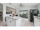 Well-lit kitchen with an island and stainless steel appliances and sliding doors to the lanai at 2306 Emerald Lake Dr, Sun City Center, FL 33573