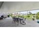 Relaxing screened lanai with outdoor dining, comfortable seating, and a view of the water at 2306 Emerald Lake Dr, Sun City Center, FL 33573