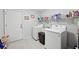 Convenient laundry room featuring a washer, dryer, ample storage, and easy access at 2306 Emerald Lake Dr, Sun City Center, FL 33573