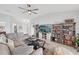 A spacious living room area features light floors, fan, sofa, and entertainment center at 2306 Emerald Lake Dr, Sun City Center, FL 33573
