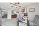 Bright living space with ceiling fan, study and sitting area, connected to bar area, all with gray carpet at 2306 Emerald Lake Dr, Sun City Center, FL 33573