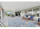 Inviting screened patio featuring wicker furniture, ample seating, and a blue patterned rug at 2306 Emerald Lake Dr, Sun City Center, FL 33573