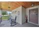Welcoming front porch features rocking chairs and wood ceiling for a cozy outdoor space at 2306 Emerald Lake Dr, Sun City Center, FL 33573