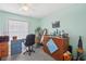 Bedroom with grey carpet, ceiling fan, window with blinds, blue desk and quirky decorations throughout at 2650 60Th N Ave, St Petersburg, FL 33714