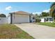 Exterior view of home showing driveway, garage, fence, and lawn with flower bed at 2650 60Th N Ave, St Petersburg, FL 33714