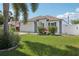 Exterior shot of home with well kept lawn, garden bed, blue door, and white trim at 2650 60Th N Ave, St Petersburg, FL 33714