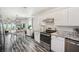 Bright kitchen featuring granite countertops, stainless steel appliances, and gray wood-look flooring at 2650 60Th N Ave, St Petersburg, FL 33714