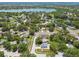 Scenic aerial shot showcases a community with a lake, a pool, and a playground surrounded by mature trees at 2692 Cedarbrooke Dr, Palm Harbor, FL 34684