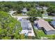 The backyard with a patio and fenced yard sits amongst mature trees in a residential neighborhood at 2692 Cedarbrooke Dr, Palm Harbor, FL 34684