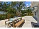 Spacious backyard patio with outdoor dining set, wooden fence, and mature trees at 2692 Cedarbrooke Dr, Palm Harbor, FL 34684