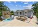 Backyard patio area with outdoor seating, a wooden fence, and lush landscaping at 2692 Cedarbrooke Dr, Palm Harbor, FL 34684