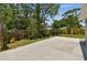 Large backyard concrete patio features wood fence, beautiful plants, and is perfect for outdoor entertainment at 2692 Cedarbrooke Dr, Palm Harbor, FL 34684