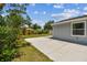 Side view of home highlighting the backyard concrete patio and lush lawn, offering relaxation and entertainment space at 2692 Cedarbrooke Dr, Palm Harbor, FL 34684