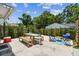 Outdoor dining on a concrete patio surrounded by a privacy fence, greenery, and a blue grill adds a touch of character at 2692 Cedarbrooke Dr, Palm Harbor, FL 34684