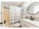 Cozy bathroom featuring a shower and a round mirror above the vanity at 2692 Cedarbrooke Dr, Palm Harbor, FL 34684