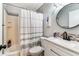 Cozy bathroom featuring a shower and a round mirror above the vanity at 2692 Cedarbrooke Dr, Palm Harbor, FL 34684
