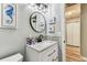 Updated bathroom featuring mosaic tile backsplash, modern fixtures, and coastal decor at 2692 Cedarbrooke Dr, Palm Harbor, FL 34684