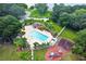 Aerial shot showcasing a community pool, playground, and lakeside location, offering resort-style living at 2692 Cedarbrooke Dr, Palm Harbor, FL 34684