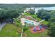 Aerial view of a sparkling community pool with a playground, surrounded by lush landscaping and a lakeside view at 2692 Cedarbrooke Dr, Palm Harbor, FL 34684