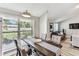 Open dining area with wood table, grey chairs, and natural light streaming through a window at 2692 Cedarbrooke Dr, Palm Harbor, FL 34684
