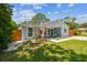 Charming single story home with light blue siding, landscaped yard, and a cozy covered front porch at 2692 Cedarbrooke Dr, Palm Harbor, FL 34684
