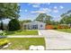 Beautiful single-Gathering home with a lush green lawn, mature trees, and well-maintained landscaping at 2692 Cedarbrooke Dr, Palm Harbor, FL 34684