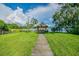Scenic gazebo overlooking the peaceful lake, accessible by a charming wooden pathway and surrounded by lush greenery at 2692 Cedarbrooke Dr, Palm Harbor, FL 34684