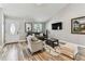 Cozy living room featuring wood-look tile floors, neutral walls, modern decor, and comfortable seating at 2692 Cedarbrooke Dr, Palm Harbor, FL 34684