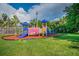 Vibrant playground equipment set on a cushioned surface, offering a safe and fun play area within the community at 2692 Cedarbrooke Dr, Palm Harbor, FL 34684